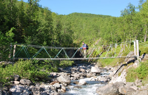 person crossing bridge over river