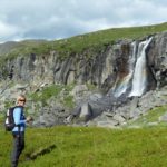 woman hiking with waterfall in the background