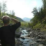 man looking down a river