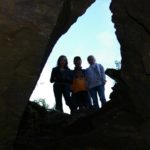 three people standing in cave entrence