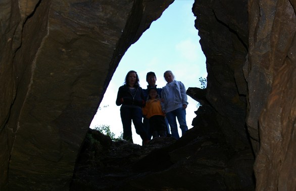 three people standing in cave entrence