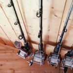 four fishing rods hanging in ceiling