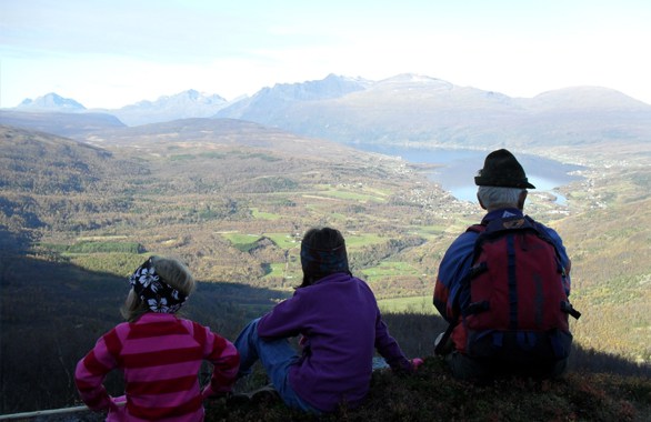 three people enjoying the view from a mountain