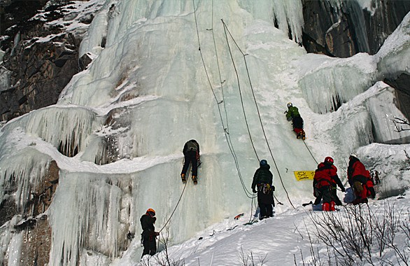 several people climbing up ice wall