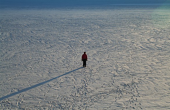person standing in flat snowy field