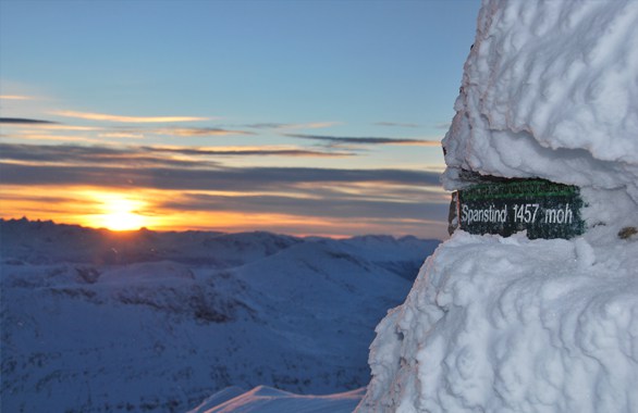 sign on top of mountain covered in snow