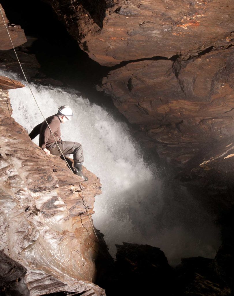 man climbing in a cave